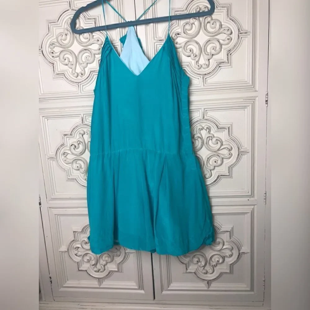 Turquoise wink romper with ruffle details size small